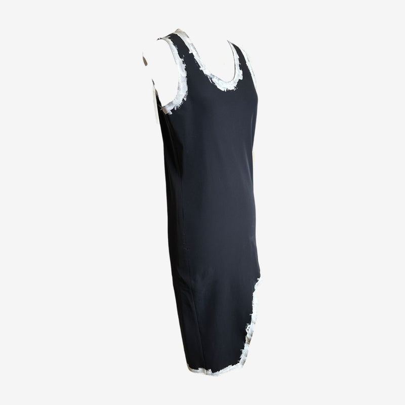 Back view of black Comme des Garçons dress with asymmetrical hemline and painted white accents
