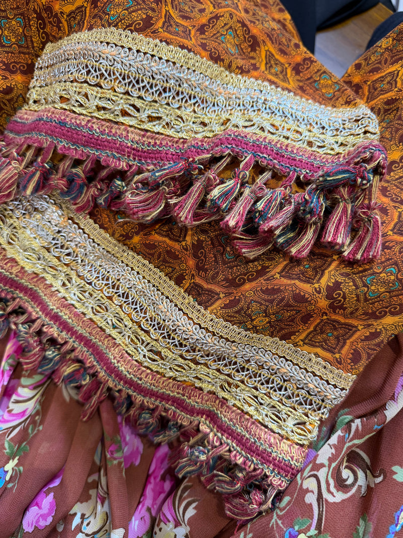 Sleeve and cuff detail of Dolce & Gabbana dress showing paisley pattern in rust and amber tones