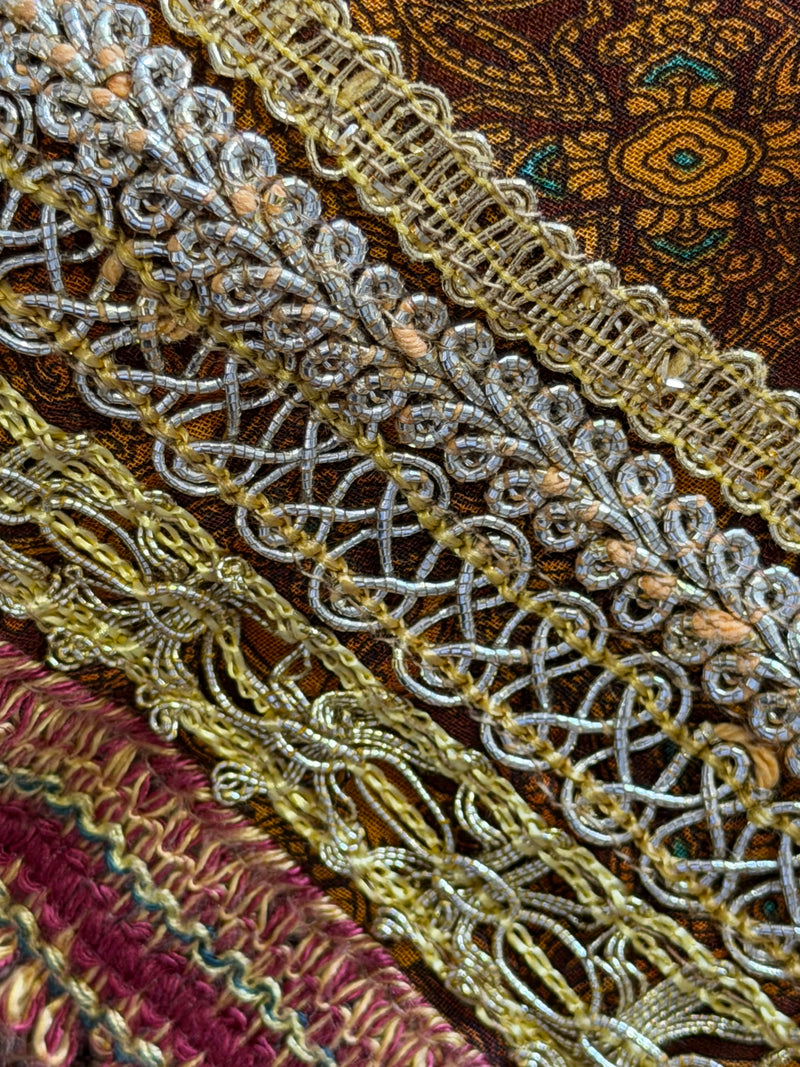Neckline and shoulder detail of mixed print silk dress by Dolce & Gabbana with decorative braided trim