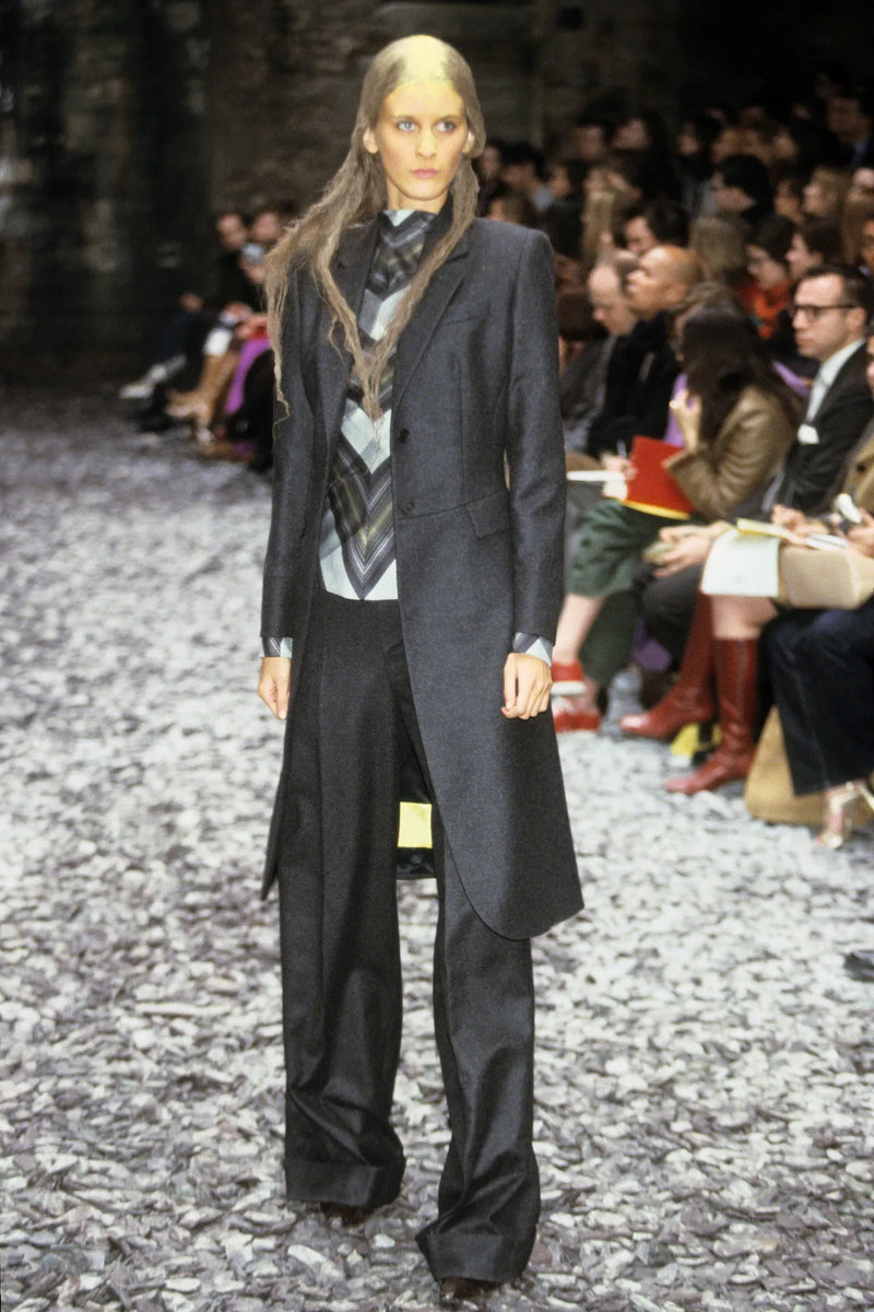 Alexander McQueen Fall 2000 runway look featuring grey tailcoat suit with morning coat proportions