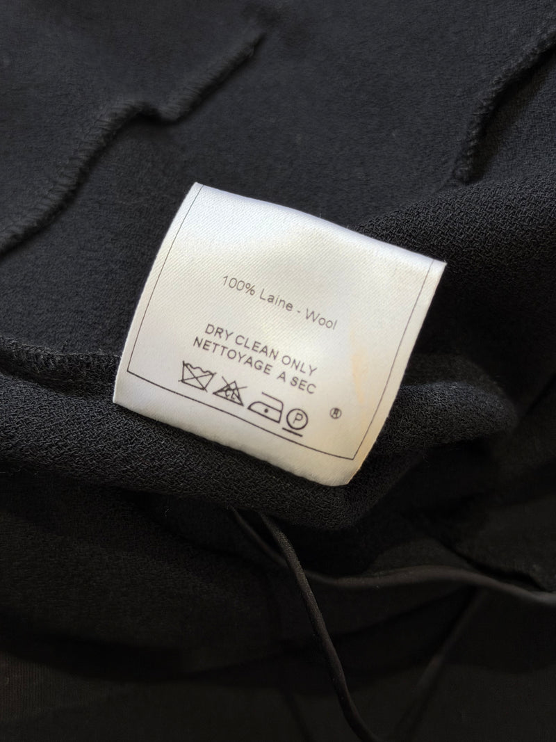 Black wool crepe mini dress by John Galliano, detail of silver-tone buckle and belt adjustment holes