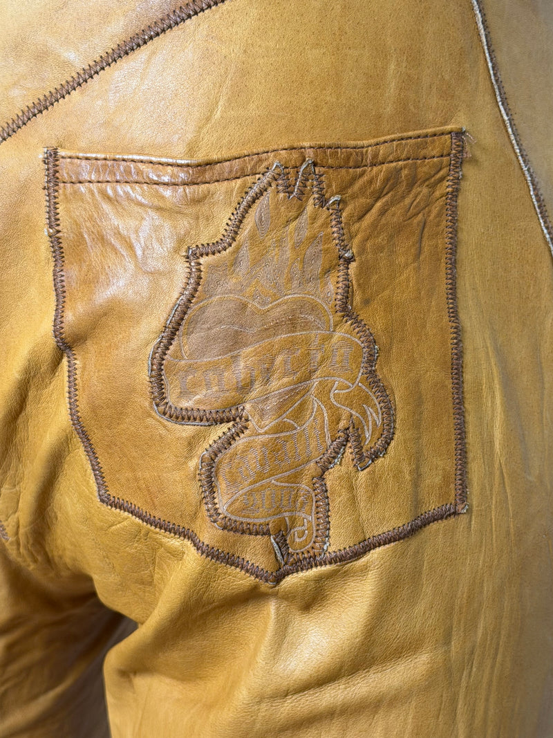 Roberto Cavalli cognac leather pants, full-length front view showing tattoo embroidery placement