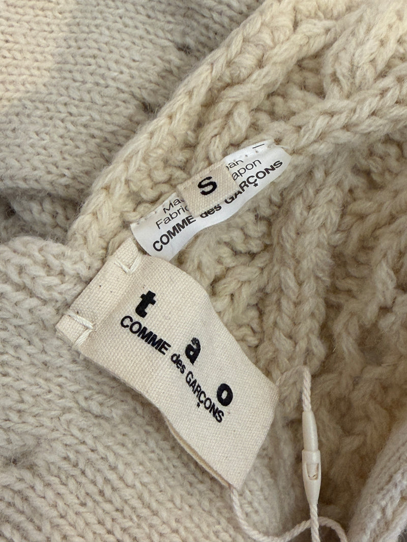 Cream cable knit dress by Tao Comme des Garçons, close-up of layered ruffled skirt hem