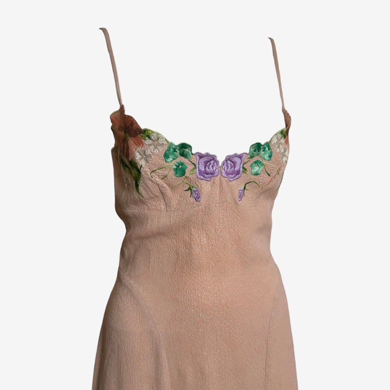 Detail of hand-embroidered floral motifs on champagne silk dress bodice