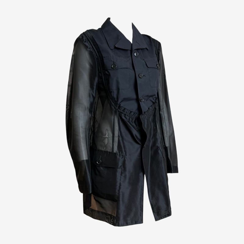 Navy military jacket by Comme des Garçons, side view showing sheer back panel and elasticated waistband