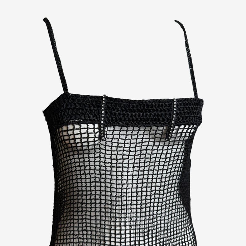 Black crochet mesh slip dress by Dolce & Gabbana, side view detail of asymmetrical hem
