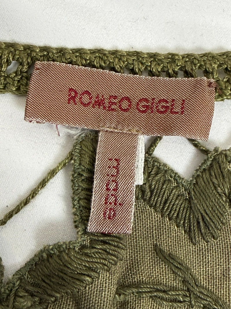 Olive green crochet vest by Romeo Gigli, Spring 1990, displayed flat showing full construction and tassel hem