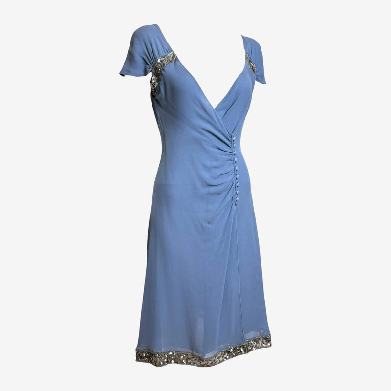 Valentino dress detail showing wrap-style bodice with self-covered buttons and flutter sleeves