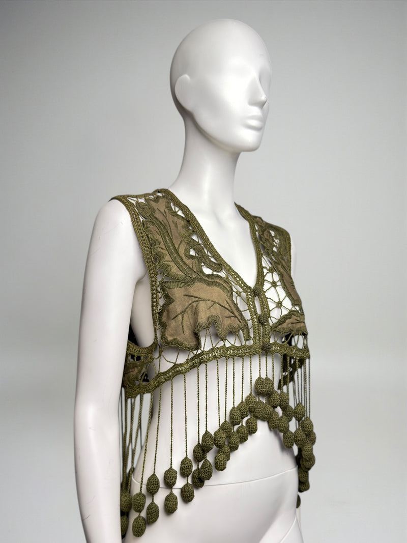 Front detail of olive green crochet vest by Romeo Gigli showing botanical appliqué and covered button closure